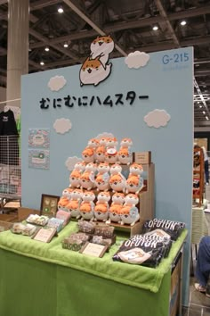 a display in a store filled with lots of cakes and pastries on top of a green table cloth