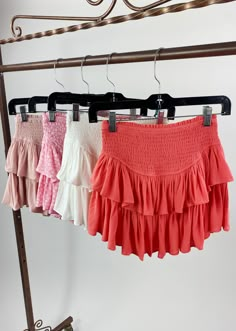 three different colored skirts hanging on a rack