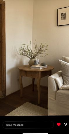 a living room with a white couch and small table in the corner next to it