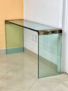 a glass table sitting on top of a tiled floor next to a white wall and door