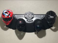 three motorcycle helmets mounted to the side of a wall with two other helmets on it