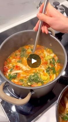 a person stirring food in a pot on the stove