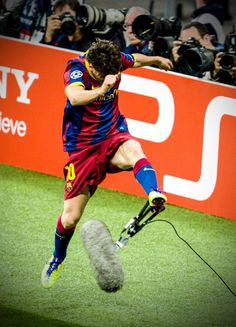 a man kicking a soccer ball on top of a field