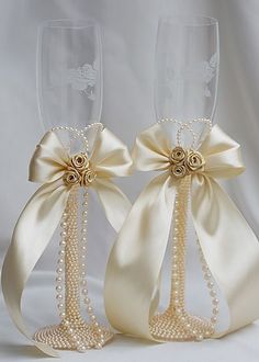 two wine glasses decorated with pearls and bows