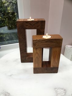 two wooden candles sitting on top of a white table