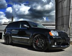 a black jeep parked in front of a silo