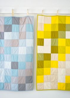 two quilts are hanging on the wall next to each other, one has a yellow and gray patchwork design