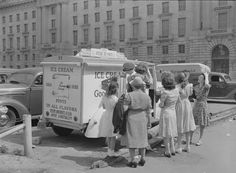 an old black and white photo of women standing in front of ice cream truck