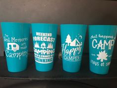 four cups with camping designs on them are sitting on a shelf next to each other