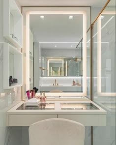 a white chair sitting in front of a vanity with a mirror on it's side