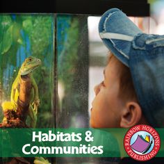 a young boy looking at a lizard in a glass case with the words habitats and communities on it