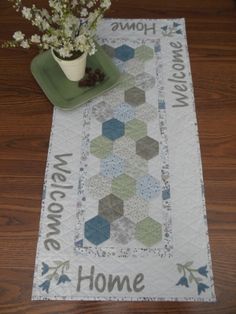 a table runner with a potted plant on it and the words welcome home written in large letters