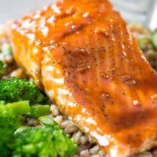 salmon and broccoli on top of rice with sauce