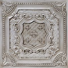 a white ceiling tile with ornate designs on it