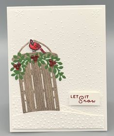 a white card with a red bird sitting on top of a wooden fence and the words let