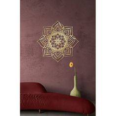 a vase with a flower in it next to a wall hanging on a purple wall