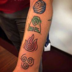 a man with a tattoo on his arm that has four symbols in different colors and shapes