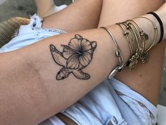 a woman's arm with a flower tattoo on the left side of her arm