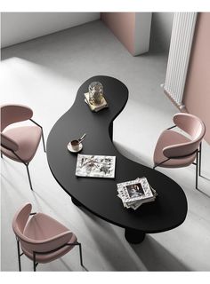 a black table with pink chairs next to it and a magazine on the table top