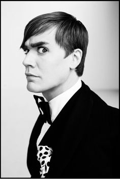 a black and white photo of a man in a suit with a polka dot tie