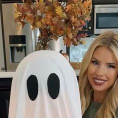 a woman standing next to a fake ghost