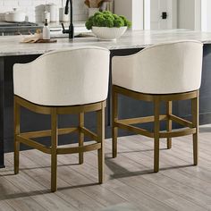 two white chairs sitting in front of a kitchen island