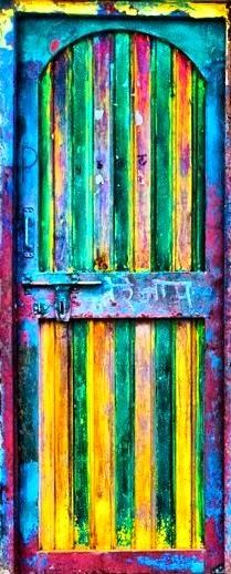 an old, colorful door with graffiti on it