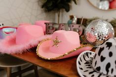 a table topped with pink hats and disco balls