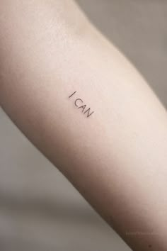 a woman's arm with the word i am tattooed on her left arm, in black ink