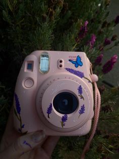 a pink camera with purple flowers on it