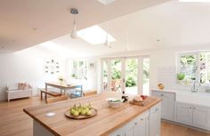 a kitchen with an island, sink, and windows in it's center area