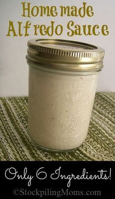 a mason jar filled with white liquid sitting on top of a green table cloth next to a sign