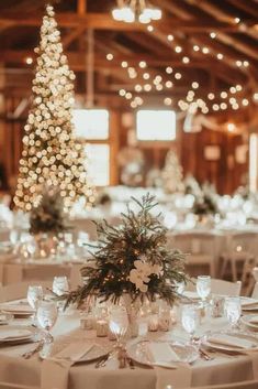 the tables are set with white linens and place settings for an elegant winter wedding