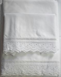 three white sheets with lace trims on them