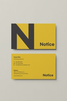 two business cards with the letter n in black, yellow and grey on top of each other