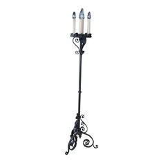 an iron candle holder with three candles on it