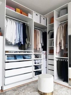 an organized closet with white drawers and clothes hanging on the shelves, along with a television