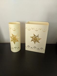 two vases sitting on top of a table next to an empty greeting card holder