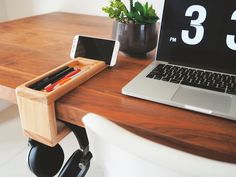 a desk with a laptop, phone and pen holder sitting on it's side