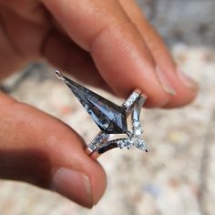 a person holding a ring with diamonds on it