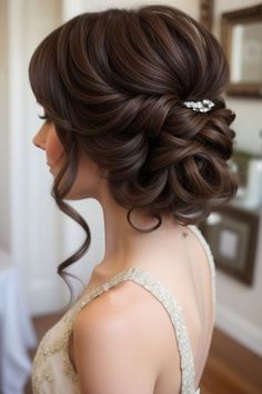 a woman in a wedding dress with her hair pinned back into a low bun style