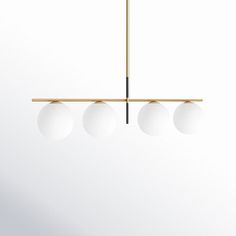 three white balls hanging from a brass chandelier with two black rods and one light fixture