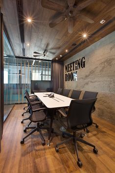 a meeting room with black chairs and a white table in front of a wall that says meeting room