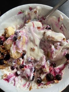 a white plate topped with fruit and ice cream covered in toppings on top of a table