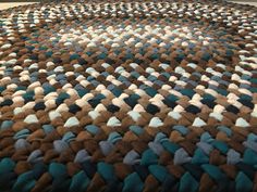 a blue, brown and white rug on the floor in a room with carpeting