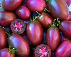 there are many different types of tomatoes on the table and one is purple with red spots