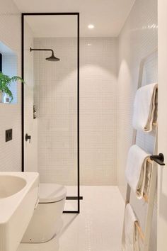 a bathroom with white tile and black accents