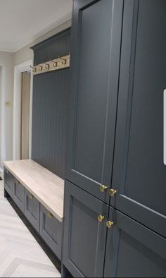 a kitchen with gray cabinets and white counter tops