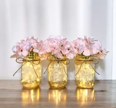 three mason jars with pink flowers in them