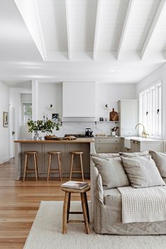 a living room filled with furniture next to a kitchen and breakfast nook on top of a hard wood floor